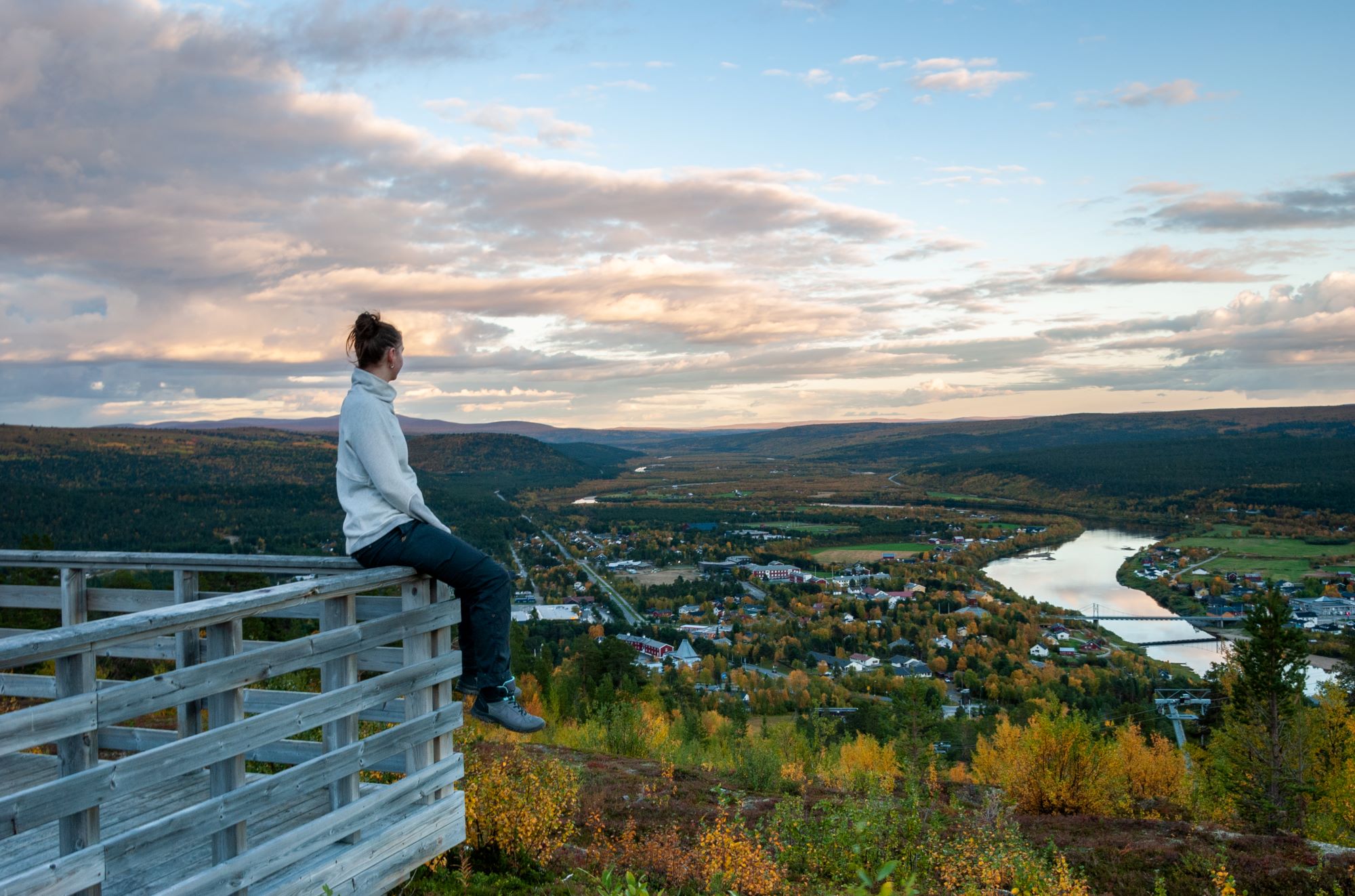 En kvinne ser utover Karasjok i kveldslys